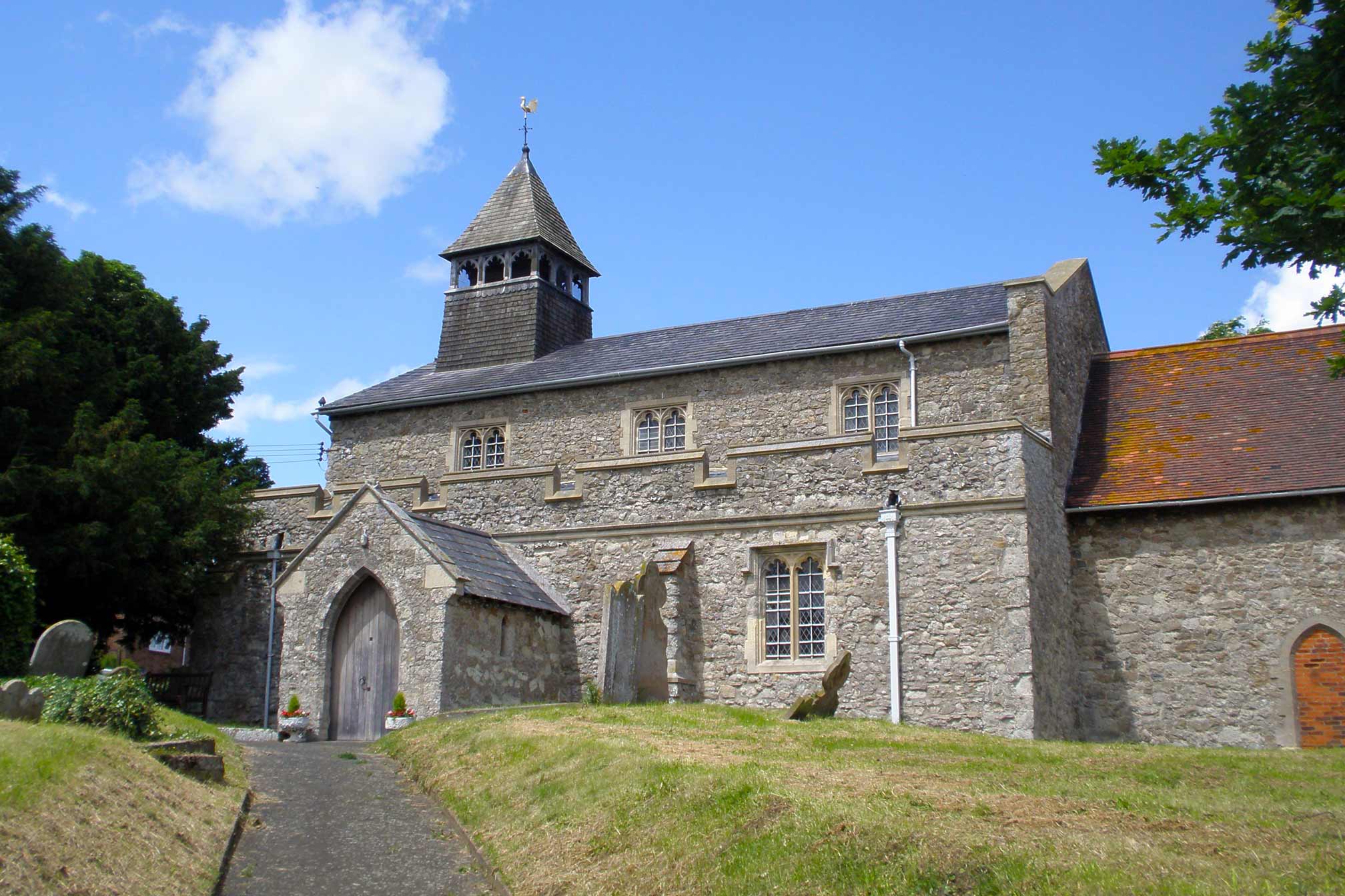 A grey stone church on a summer day